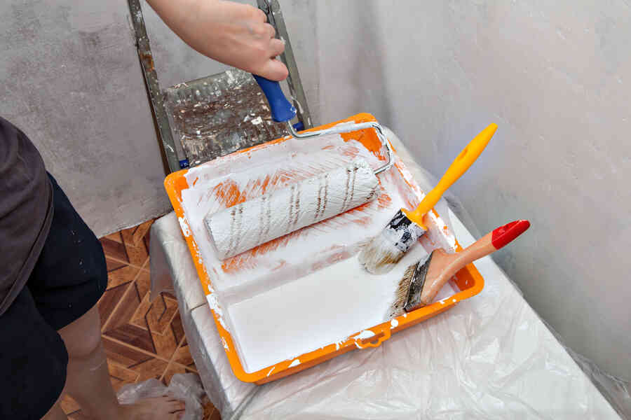 Paintbrushes and rollers in a paint tray